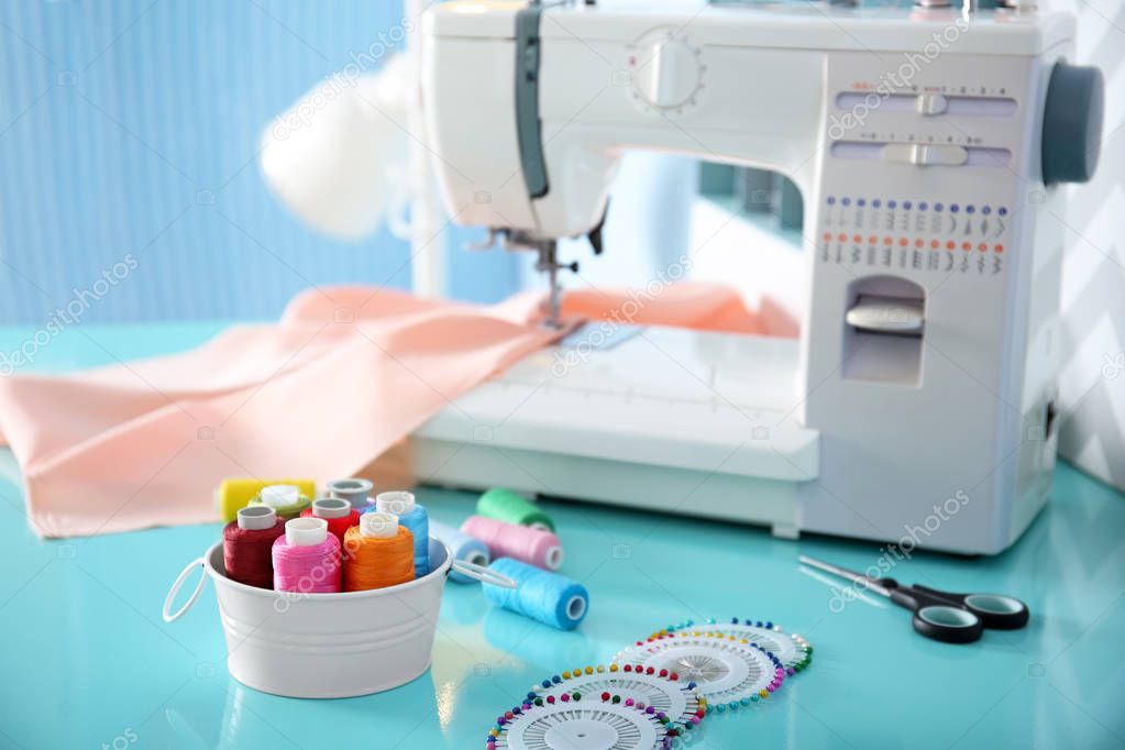 Colorful threads and sewing machine on table