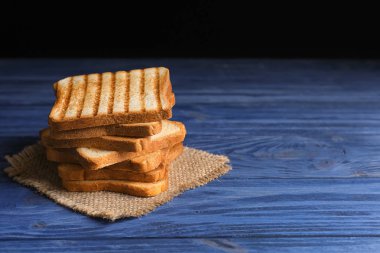 Mavi ahşap arka plan üzerinde yığılmış kızarmış ekmek dilimleri