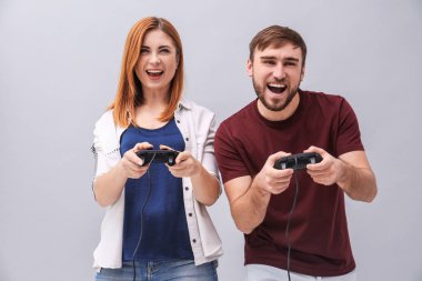 Video oyun denetleyicisi gri arka plan üzerinde olan duygusal Çift