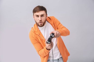 Video oyun denetleyicisi gri arka plan üzerinde olan duygusal adam