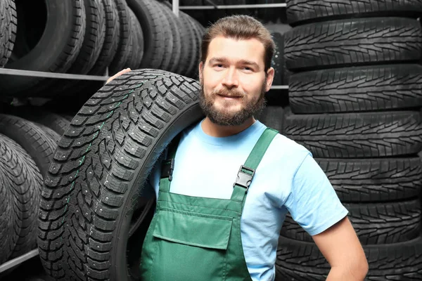 Férfi szerelő, autó gumiabroncs, autó üzletben — Stock Fotó