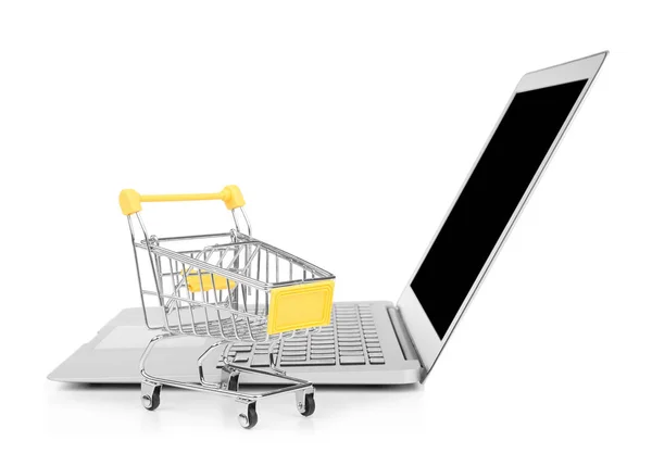 Laptop en kleine winkelwagentje op witte achtergrond. Internet shopping concept — Stockfoto