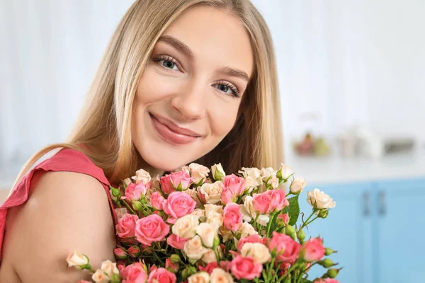 Όμορφη νεαρή γυναίκα με μπουκέτο τριαντάφυλλα στο σπίτι — Φωτογραφία Αρχείου