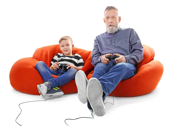 Χαριτωμένο αγόρι με παππού παίζει video game σε λευκό φόντο — Φωτογραφία Αρχείου