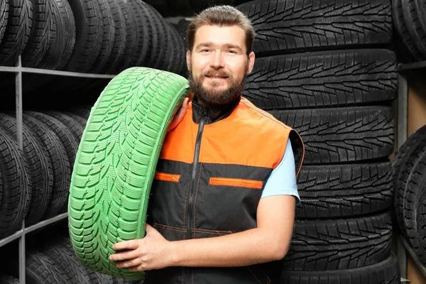 Mannelijke monteur met kleur auto band in auto winkel — Stockfoto