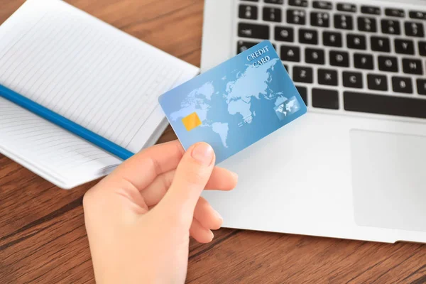 Mulher com cartão de crédito e laptop à mesa, close up. Conceito de compras na Internet — Fotografia de Stock