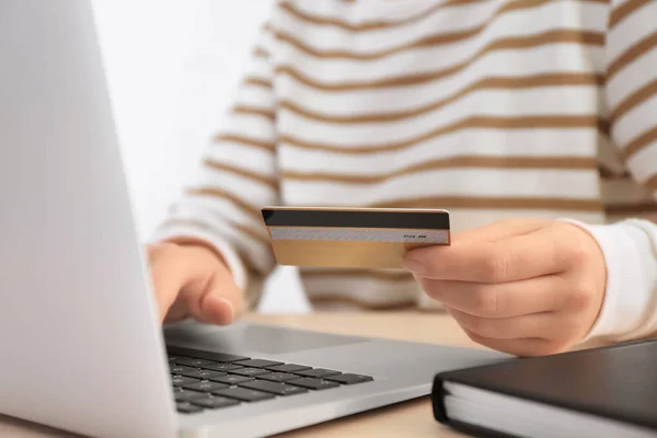 Frau mit Kreditkarte und Laptop am Tisch, Nahaufnahme. Einkaufskonzept im Internet — Stockfoto