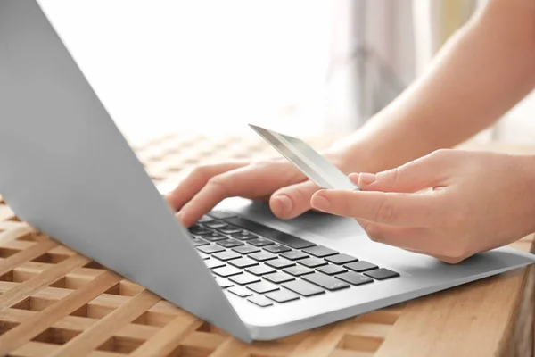 Mulher segurando cartão de crédito ao usar laptop, close-up. Conceito de compras na Internet — Fotografia de Stock