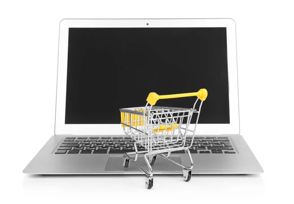 Laptop und kleiner Warenkorb auf weißem Hintergrund. Einkaufskonzept im Internet — Stockfoto
