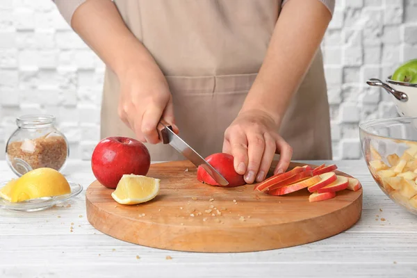 Mujer cortando manzanas en la cocina — Foto de Stock