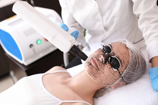 Young woman undergoing carbon peeling procedure in salon — Stock Photo, Image