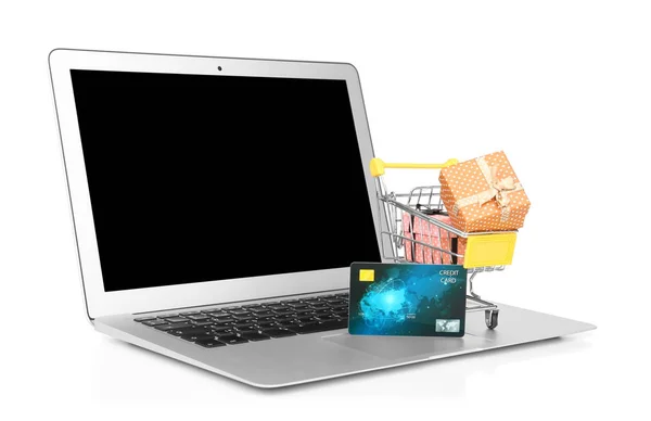 Laptop, credit card en kleine winkelwagentje met geschenkdozen op witte achtergrond. Internet shopping concept — Stockfoto