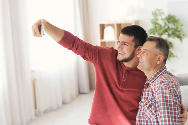 Junger Mann macht Selfie mit seinem Vater zu Hause — Stockfoto