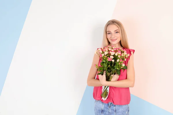 Bella giovane donna con mazzo di rose su sfondo di colore — Foto Stock