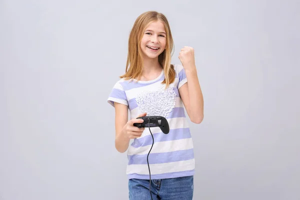 Щаслива дівчина-підліток з контролером відеоігор на сірому фоні — стокове фото
