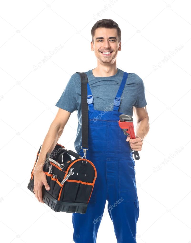 Young plumber in uniform with tool bag and pipe wrench on white background