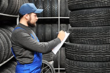 Erkek makinist araba lastikleri otomobil yakınındaki pano ile mağaza