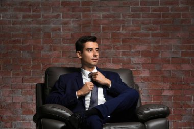 Tuğla duvar arka plan üzerinde şık elbiseli adam