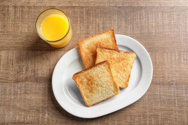 Kızarmış ekmek ve bardak suyu ahşap masa üzerinde plaka
