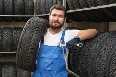 Otomobil dükkanında somun anahtarı ve araba lastiği ile erkek makinist
