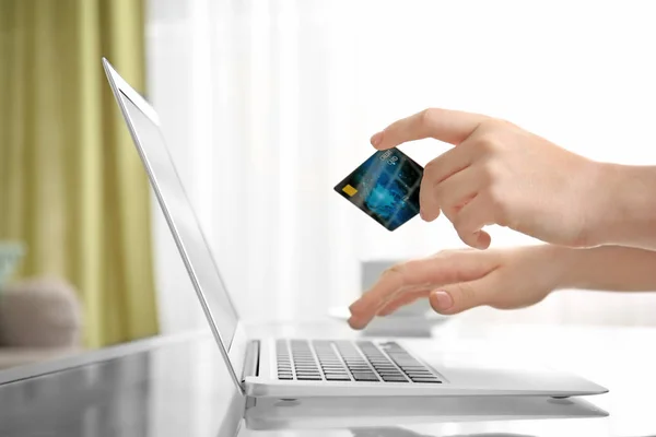 Mujer sosteniendo la tarjeta de crédito mientras usa el ordenador portátil en casa. Concepto de compras por Internet —  Fotos de Stock