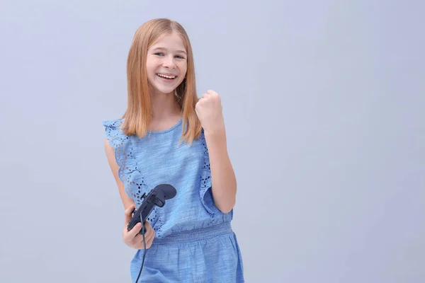 Gelukkig tienermeisje met video game controller op kleur achtergrond — Stockfoto