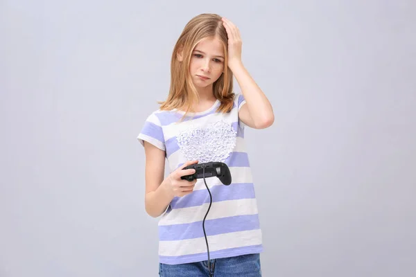Teenager-Mädchen mit Videospiel-Controller auf grauem Hintergrund verärgert — Stockfoto