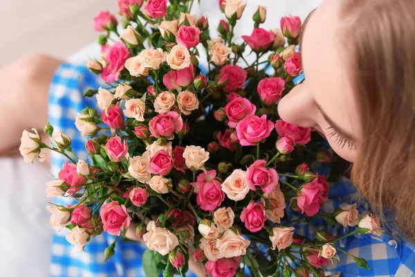Mulher bonita com buquê de rosas, dentro de casa — Fotografia de Stock
