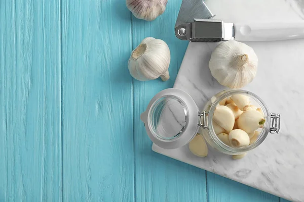Vaso con spicchi d'aglio e teste su fondo di legno — Foto Stock