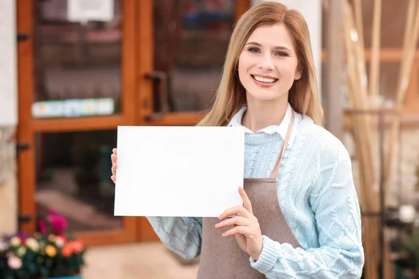 Właściciel firmy, trzymając papier blank w pobliżu swojego sklepu, na zewnątrz — Zdjęcie stockowe