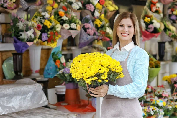 Business owner holding bouquet of flowers near her store — Stock Photo, Image