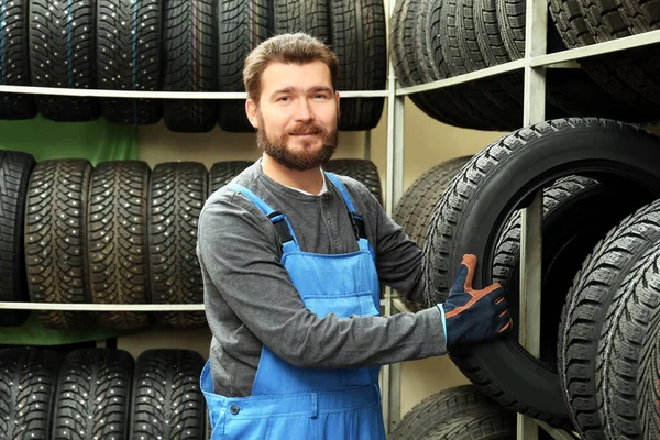 Férfi szerelő, autó gumiabroncs, autó üzletben — Stock Fotó