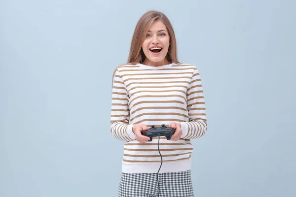 Glückliche Frau mit Videospielcontroller auf farbigem Hintergrund — Stockfoto
