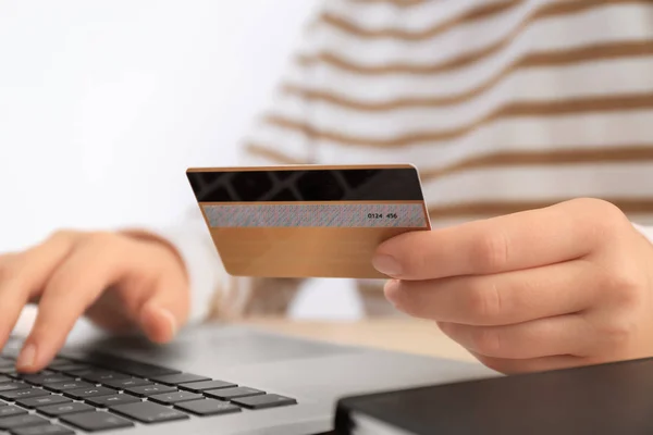 Mulher com cartão de crédito e laptop à mesa, close up. Conceito de compras na Internet — Fotografia de Stock