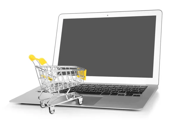 Dizüstü bilgisayar ve küçük alışveriş sepeti beyaz arka plan üzerinde. Internet alışveriş kavramı — Stok fotoğraf