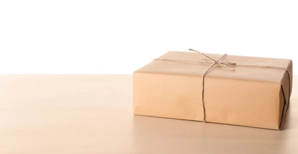 Caixa de presente do pacote na mesa de madeira contra fundo branco — Fotografia de Stock
