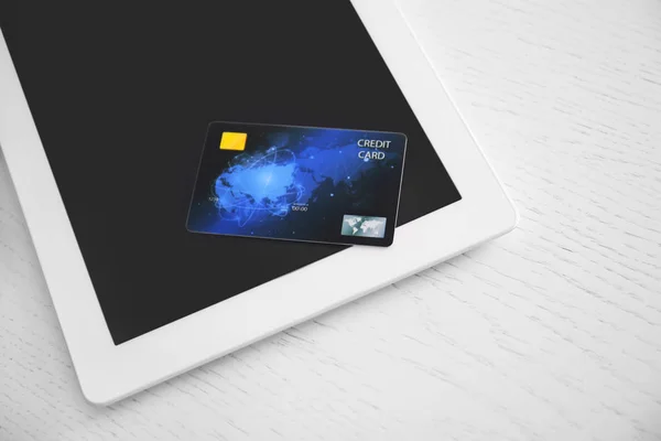 Tablet ordenador y tarjeta de crédito en la mesa, primer plano. Concepto de compras por Internet — Foto de Stock