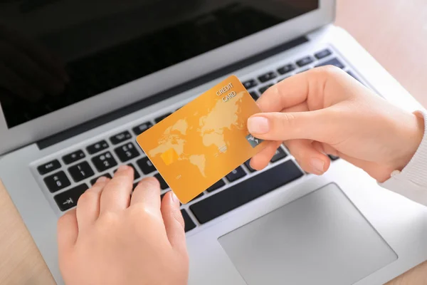 Mulher com cartão de crédito e laptop à mesa, close up. Conceito de compras na Internet — Fotografia de Stock