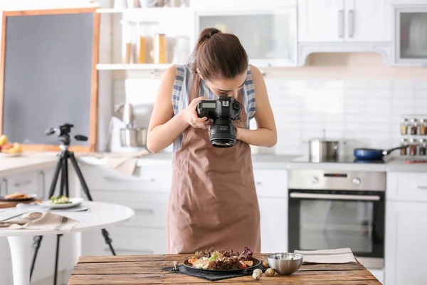 Mladá žena s profesionálním fotoaparátem fotit zátiší v kuchyni — Stock fotografie