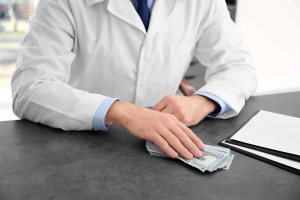 Врач со взяткой на рабочем месте

