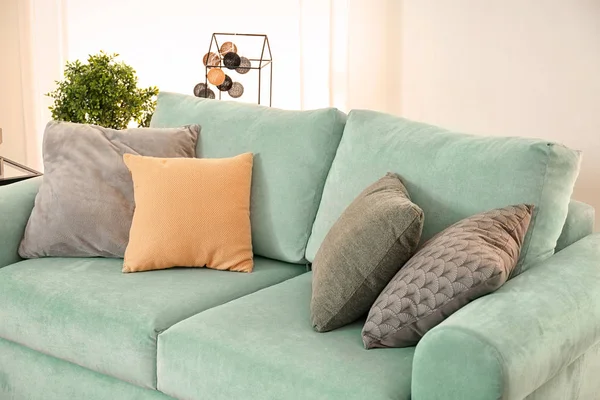 Комфортный мятный диван с подушками в гостиной — стоковое фото