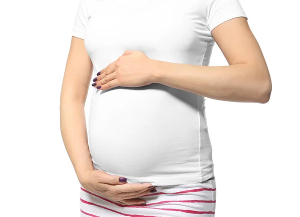 Pregnant woman in pajamas holding hands on belly against white background — Stock Photo, Image