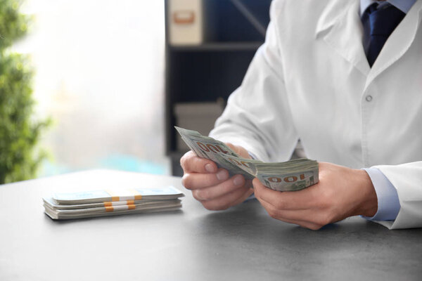 Врач со взяткой на рабочем месте
