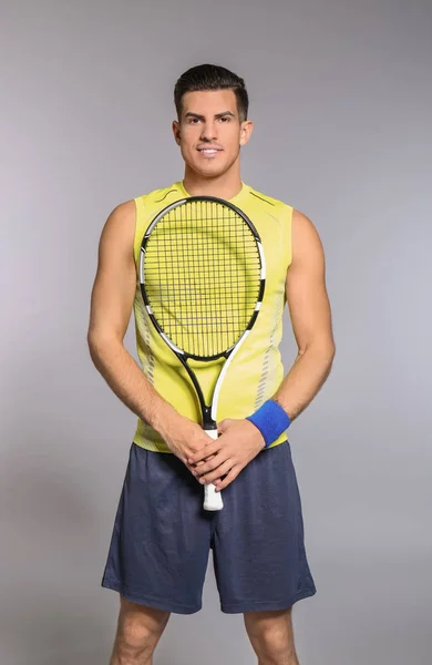 Portret van knappe man tennissen tegen de grijze achtergrond — Stockfoto