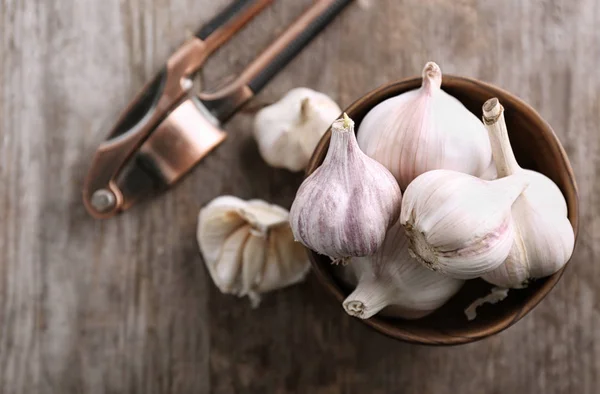 Bowl with fresh garlic on wooden table — Stock Photo, Image