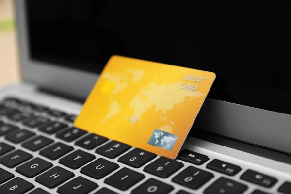 Credit card on laptop keyboard, closeup. Internet shopping concept — Stock Photo, Image