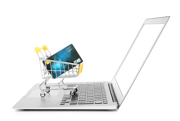 Laptop e piccolo carrello con carta di credito su sfondo bianco. Internet shopping concept — Foto Stock