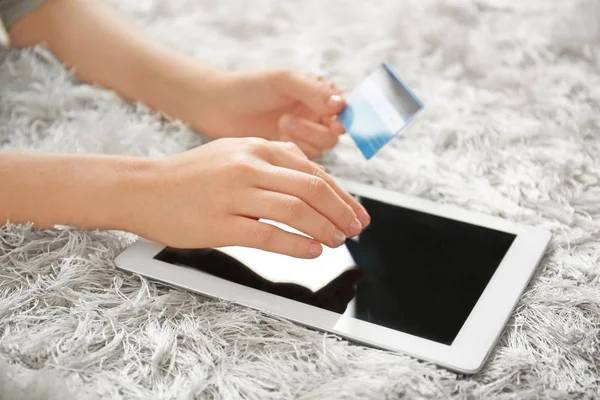 Mulher segurando cartão de crédito ao usar computador tablet em casa, close-up. Conceito de compras na Internet — Fotografia de Stock