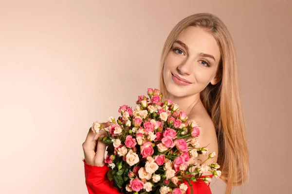 천연색 배경에 장미 꽃다발을 단 아름다운 젊은 여자 — 스톡 사진