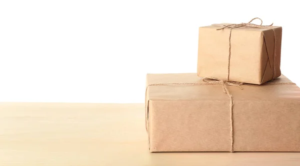 Paket-Geschenkboxen auf dem Tisch vor weißem Hintergrund — Stockfoto